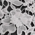 Detailed view of white water-soluble lace fabric with 3D milk silk floral embroidery - White
