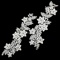 Detailed view of white water-soluble floral lace appliques on a black background - White