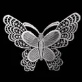 Detailed macro view of white embroidered butterfly lace patch for clothing decoration. - White