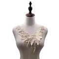 Detail of champagne floral water-soluble lace applique embroidery on mannequin neck - Beige