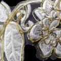 Macro detail of white and gold corded lace trim with intricate floral patterns. - 15 Yards/Pack / Platinum