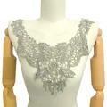 Vue détaillée d'une applique en dentelle florale argentée sur un mannequin de couture - Style Gris