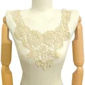 Gros plan détaillé d'une applique de col en dentelle florale beige sur un mannequin - Style Beige