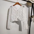 Close-up of white bohemian crochet lace cardigan with hollow floral embroidery details - Tops / White