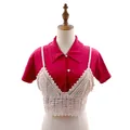 Dettaglio di un crop top all'uncinetto color crema indossato sopra una camicia rossa - Top / Albicocca
