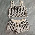 Macro view of handmade crochet knit two-piece set with elegant wave hem patterns - Top And Bottom / Black