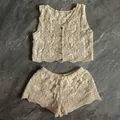 Close-up detail of a bohemian cream crochet knit set with a floral vest and shorts. - Apricot