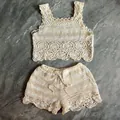 Détail à plat d'un joli ensemble haut court et short en tricot crochet beige pour l'été - Abricot