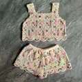 Detailed look at colorful embroidered floral patterns on a white crochet knit two-piece set - Top And Bottom / Rainbow