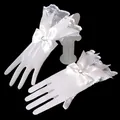 Detail of white lace bridal gloves with satin bow and rhinestone decoration - White