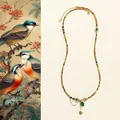Détail du collier de perles en tourmaline avec pendentif cœur vert et breloque trèfle - Pendentif Cœur Tourmaline Verte