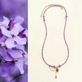 Vue détaillée d'un collier en perles d'améthyste avec pendentifs cœur et goutte d'or - Pendentif Cœur Améthyste