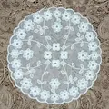 Detail view of round white lace coaster with delicate floral embroidery and mesh base - White / 46# (Floral Scroll)