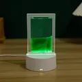 Primer plano detallado de una lámpara de arena movediza que brilla verde en la mesa - Verde