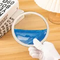 Primer plano de un adorno circular de arte de arena móvil 3D con arena fluida azul y dorada. - Blue sand table [without base]