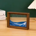 Primer plano de un cuadro de arena movediza 3D con marco de madera en escritorio. - Cuadro Arena Marco Madera / 17.5X12.5X4CM / Azul cielo