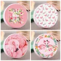 Detailansicht von vier runden Blech-Münzbörsen mit rosa Flamingo-Blumen-Designs. - Pinkfarbener 4-Farben Flamingo
