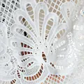 Gros plan sur un tissu de dentelle soluble à l'eau avec une broderie de paon. - Blanc