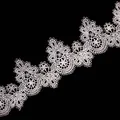 Detailed view of intricate white water-soluble lace trim with 3D hollow embroidery - White