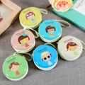 Draufsicht auf bunte Weißblech-Münzbörsen mit charmanten Cartoon-Mädchen-Designs und Trageschlaufen - Mädchen