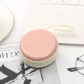 Dettaglio di una custodia rotonda rosa macaron con cerniera per monete e cuffie, stile mini - Pesca