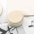 Dettaglio di un mini astuccio rotondo in banda stagnata con cerniera e cinturino - Beige