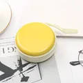Primo piano di un portamonete tondo giallo in banda stagnata con cerniera bianca - Giallo