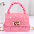 Stilvolle pinkfarbene Mini-Gelee-Handtasche mit geflochtenem Griff und eleganter Goldkette - Rosa