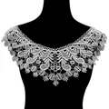 Macro detail view of elegant white water-soluble lace collar with floral embroidery patterns - White