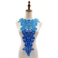 Detail view of bright blue water-soluble lace neck applique with intricate embroidery - Blue