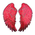 Nahaufnahme von leuchtend roten Pailletten-Flügel-Patches mit schimmernder Textur und Glanz - Rot