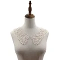 Detailed macro view of white water-soluble lace collar on a dress form mannequin - Apricot