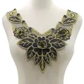 Detail einer schweren Goldstickerei-Blumenapplikation mit 3D-Rose auf schwarzem Netzbund. - Schwarz & Gold