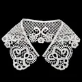 Detailed view of a white water-soluble lace collar with intricate hollow-out floral patterns. - White