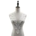 Detalle de aplique de encaje blanco para escote con bordado floral en un maniquí de costura. - Blanco