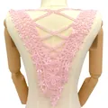 Detailansicht der rosa Blumen-Spitzenapplikation auf dem Rücken einer Holzpuppe - Rosa