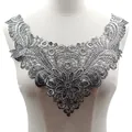 Vue détaillée du col en dentelle brodée argentée avec motifs floraux métalliques. - Estampillage à chaud