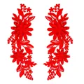 Primo piano di toppe simmetriche ricamate in pizzo floreale rosso con dettagli traforati - Patch Simmetrica / Rosso Brillante