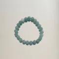 Close-up of natural aventurine jade bead bracelet with light green round stones - Aventurine Round Beads / Bronze Green