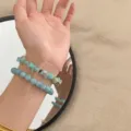 Detailansicht von gestapelten Naturstein- und hellgrünen Aventurin-Jade-Armbändern. - Stapelset (Rund und Zerstoßen) / Bronzegrün und Bronzegrün