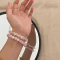 Detailansicht von handgefertigten rosa Natursteinperlen-Armbändern am Handgelenk. - Stapelset (Rund und Zerstoßen) / Hellviolett und Hellrosa