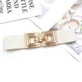Detail view of the white elastic waistband showing the stylish interlocking gold square metal buckle. - White