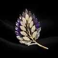 Detailed shot of exquisite gold wheat leaf brooch with purple and clear cubic zirconia stones. - Purple Maple Leaf