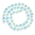 Primo piano dettaglio di perline rotonde piatte in vetro chiaro con motivi di fiori. - Fiore Giallo Blu Chiaro