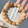 Macro view of Bodhi seed bracelet featuring Six Syllable Mantra engravings on beads - Multi-Treasure Mantra Style
