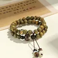 Handcrafted green sandalwood double-strand bracelet featuring zodiac guardian symbol charm - Ox & Tiger (Akasagarbha Bodhisattva)