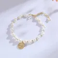 Detail view of a handcrafted freshwater pearl bracelet with a golden coin pendant - Goddess Portrait Pearl Style