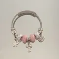 Vue détaillée d'un bracelet à breloques en acier inoxydable avec perles roses. - Style Bracelet Jonc / Rose