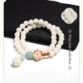 Detail view of white jade bodhi root bracelet with wooden flower charm and green bead - Double Wrap Lotus Style / White