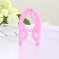Portable folding travel clothes hanger in vibrant pink finish for compact luggage storage - Pink